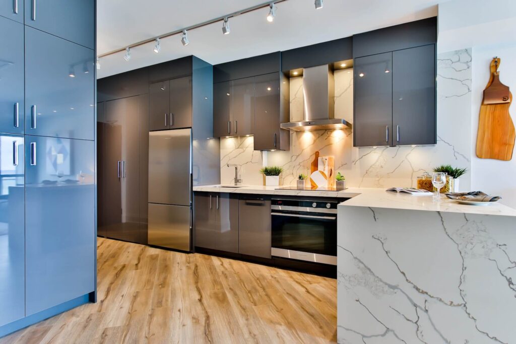 Well-lit kitchen with white countertops and blue cabinets.