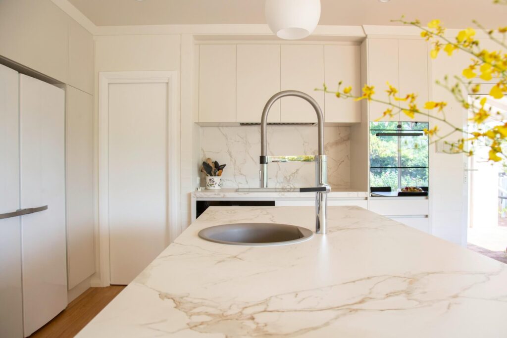 An empty kitchen with marble countertops.