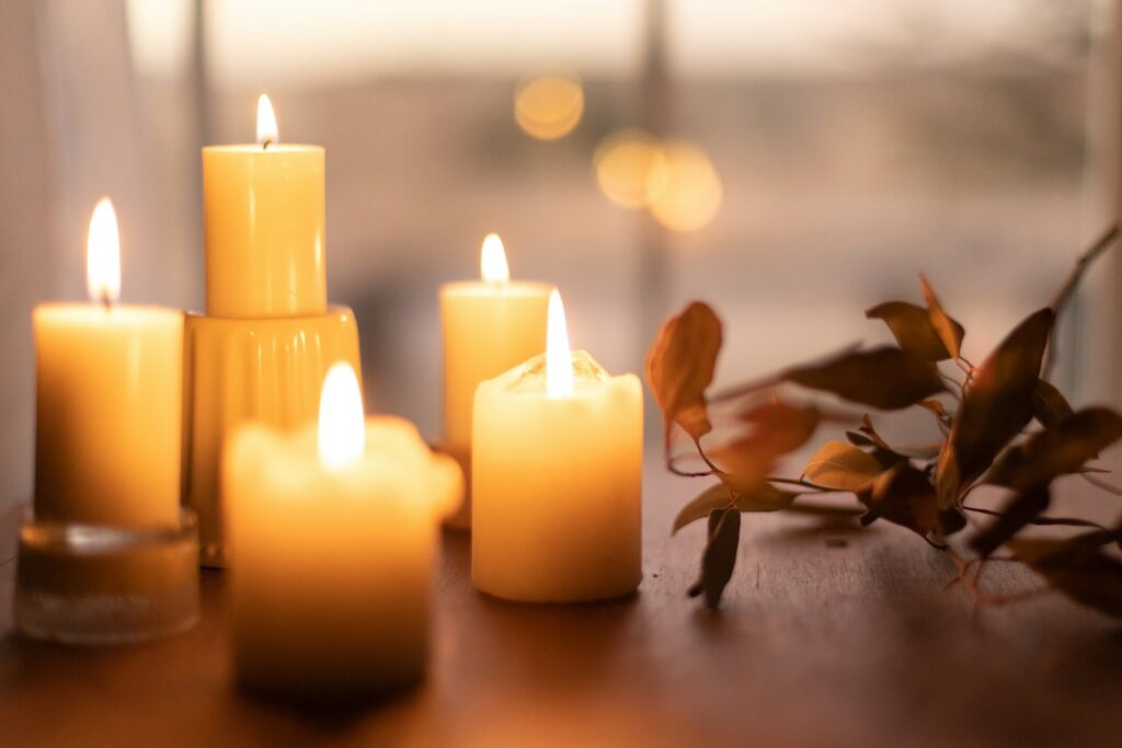 Candle Burning Next to Leaves