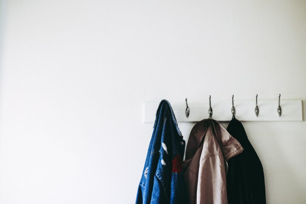 three coats hanging on hooks