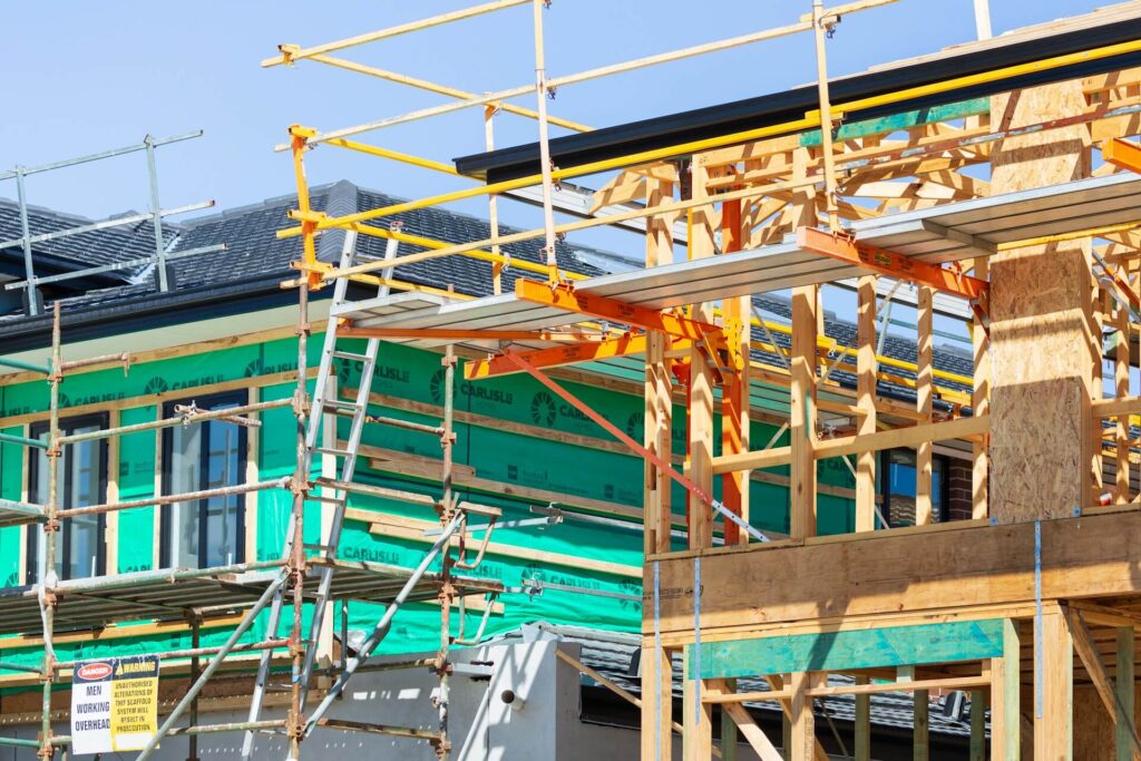 A house under construction with scaffolding on the roof