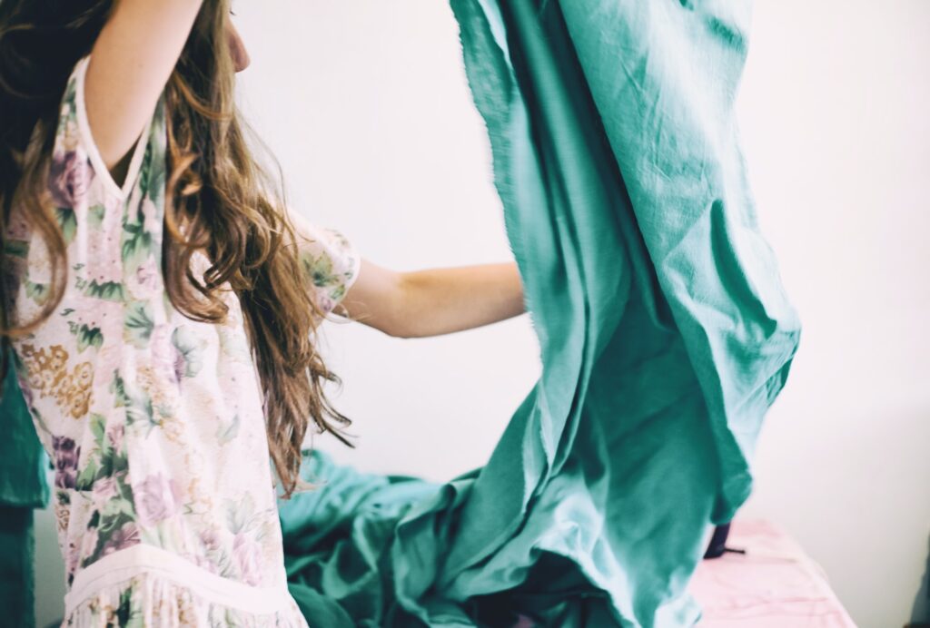 a brunette in a floral dress with a teal cloth