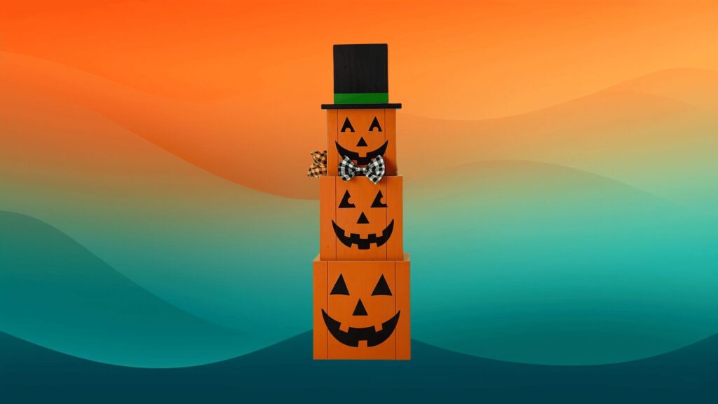 stacked wooden pumpkin decor with a top hat on in front of an orange and teal background