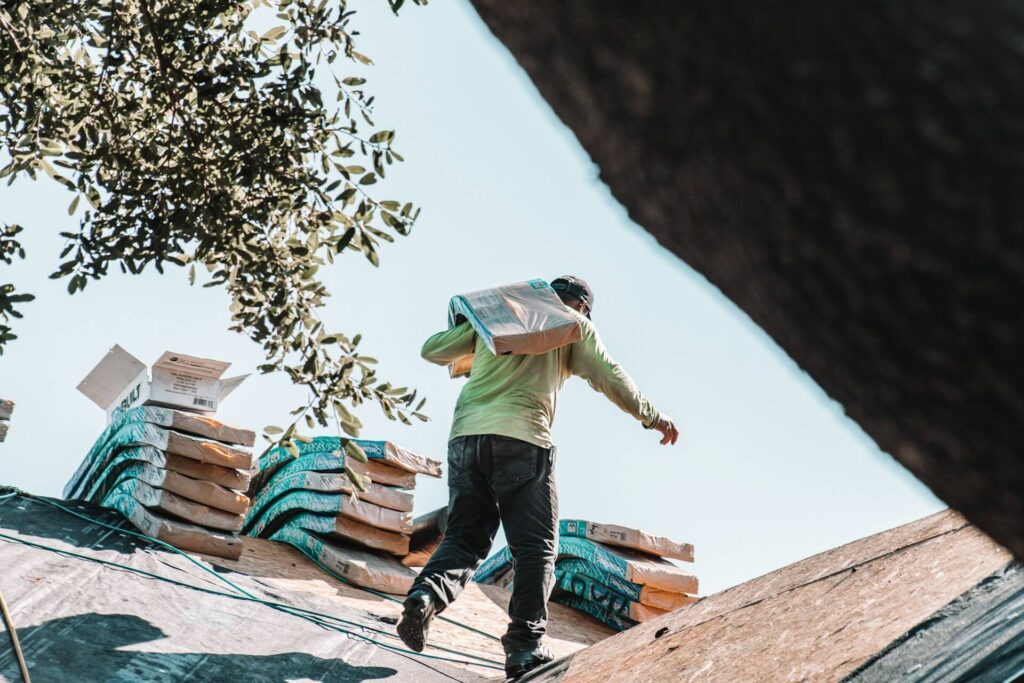 Construction worker carrying shingles for the roof