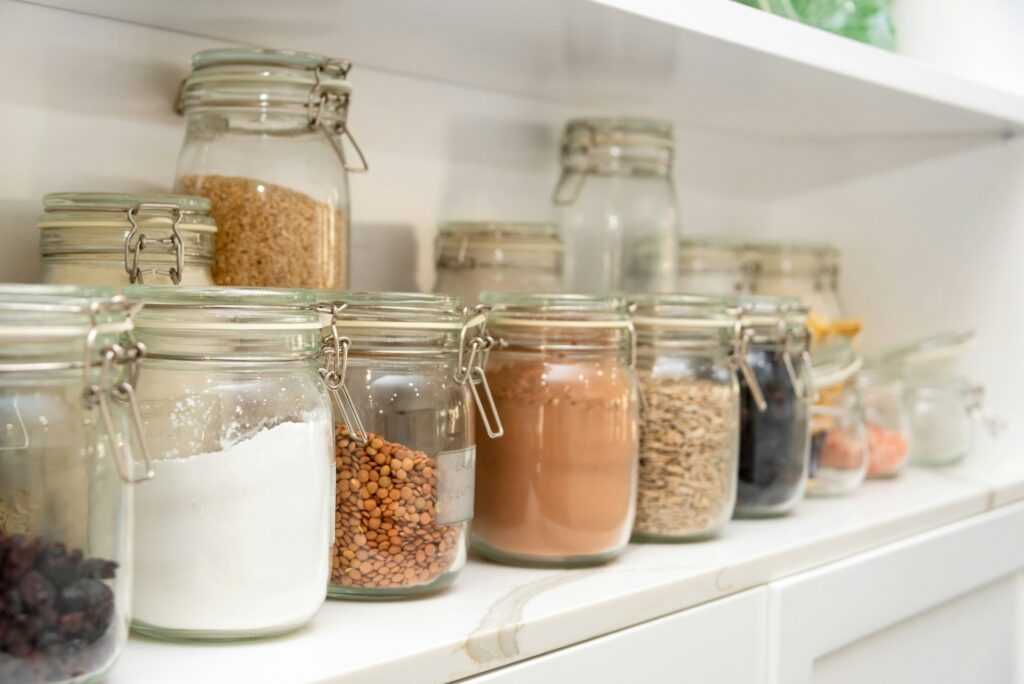 A well-arranged shelf featuring an assortment of jars containing spices and preserved foods, showcasing vibrant colors.
