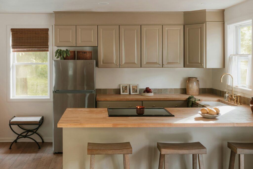 A well-equipped kitchen showcasing a refrigerator and stove, surrounded by wooden cabinets and a clean countertop.
