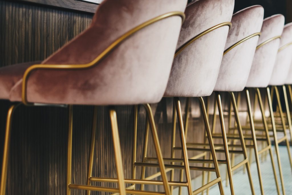 A row of pink velvet chairs with brass legs