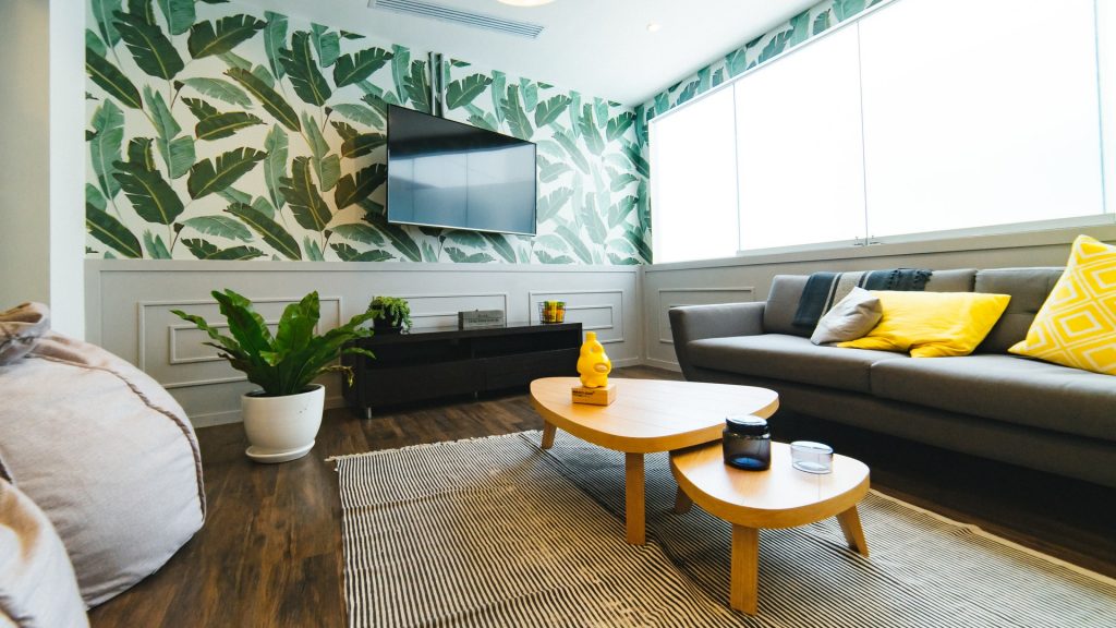 Living room with wallpaper of green jungle leaves print