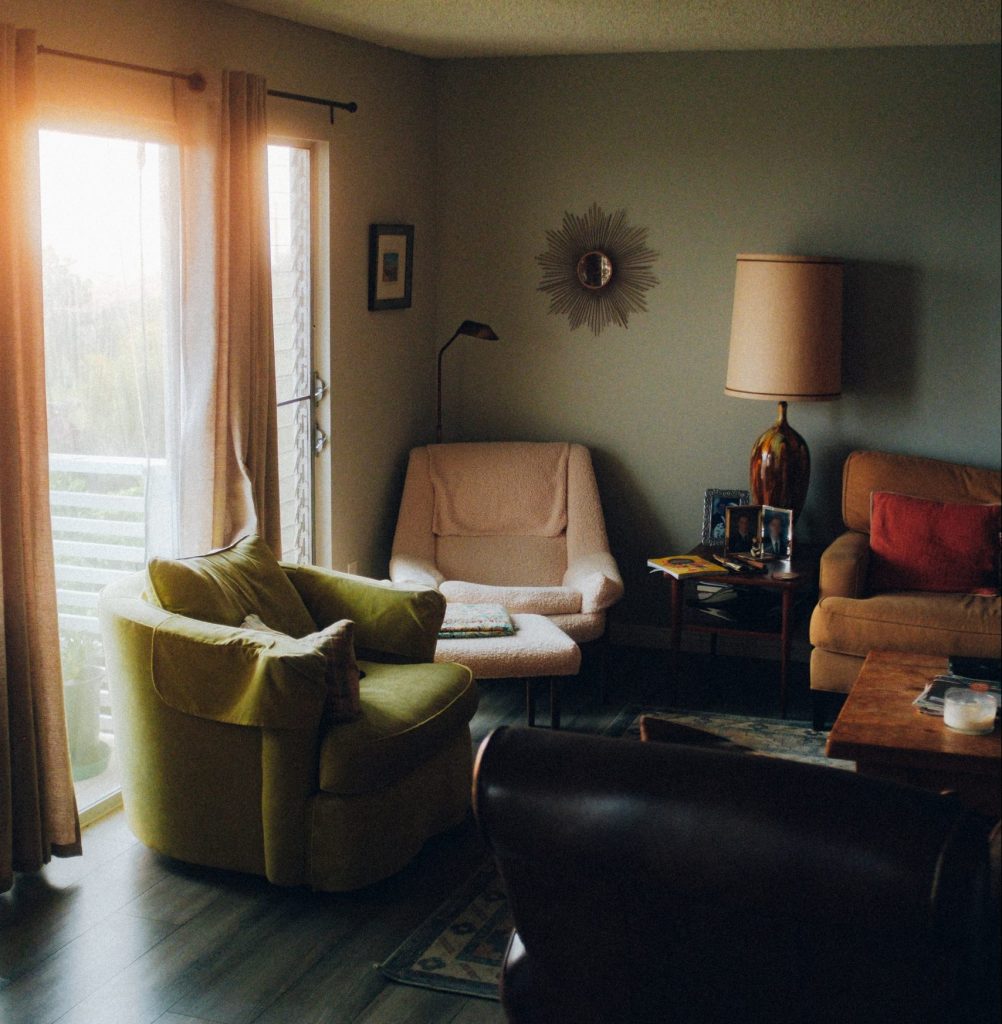 A living room with different colored old furniture