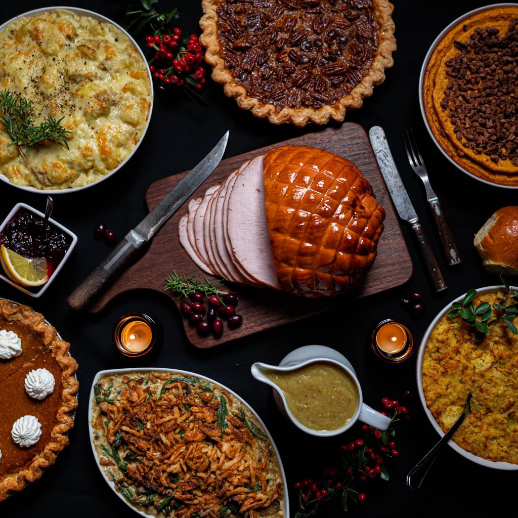 A variety of Thanksgiving dishes displayed on a black table