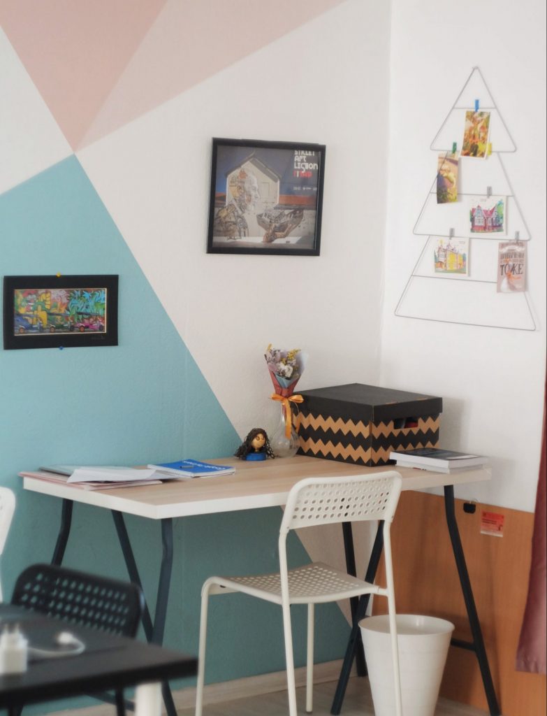 A desk with colorful geometric painted walls