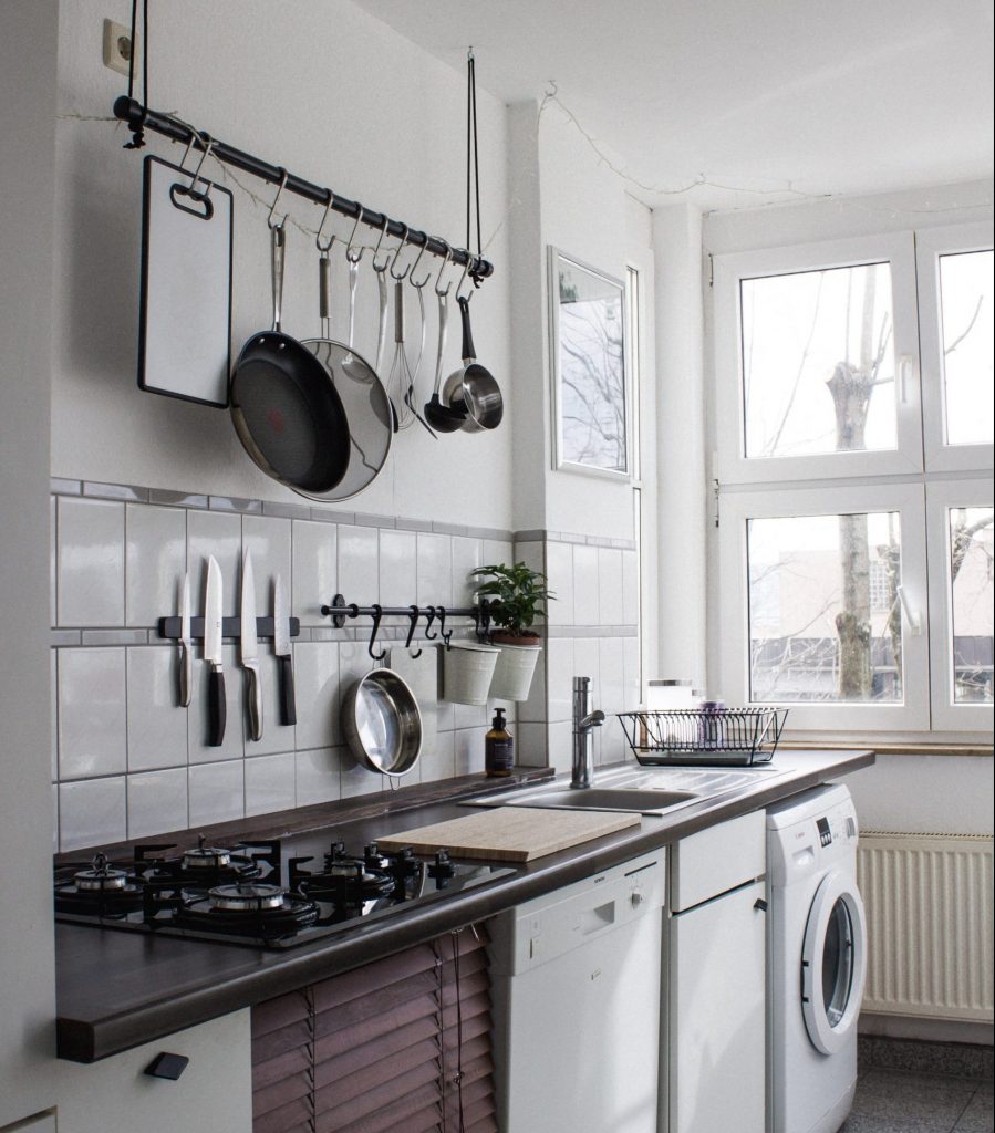 A variety of kitchen tools and pots hung above the stove and sink