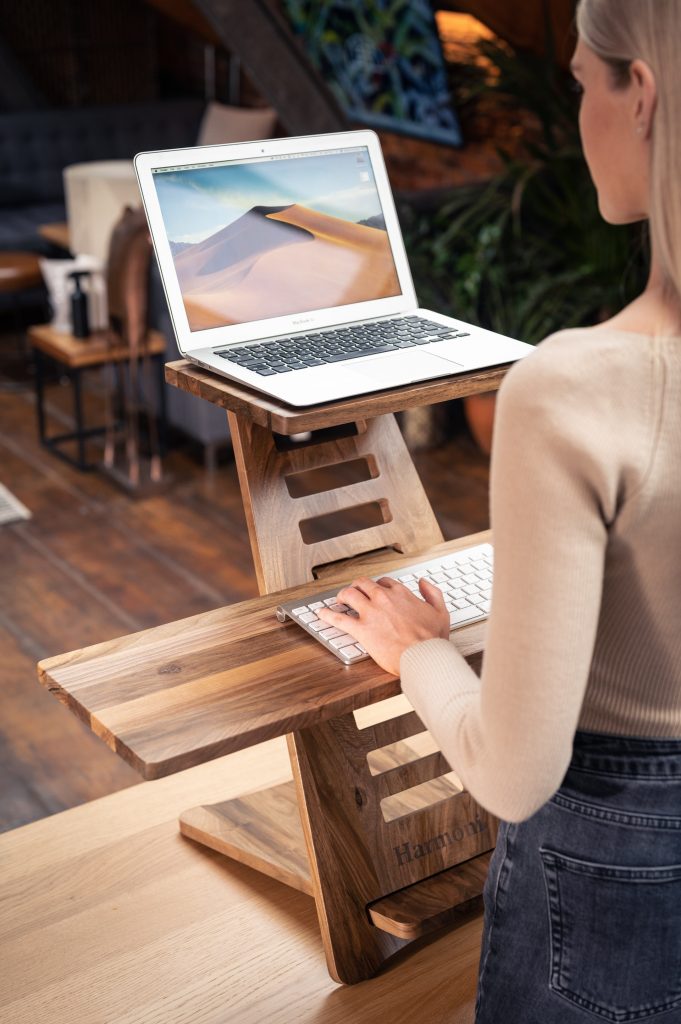 A small collapsible standing desk being used by a woman