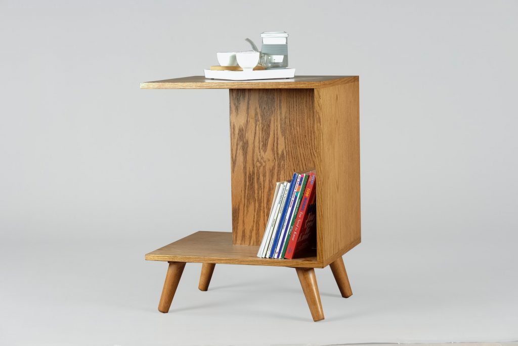 Wooden c-shaped side table with books and tea set