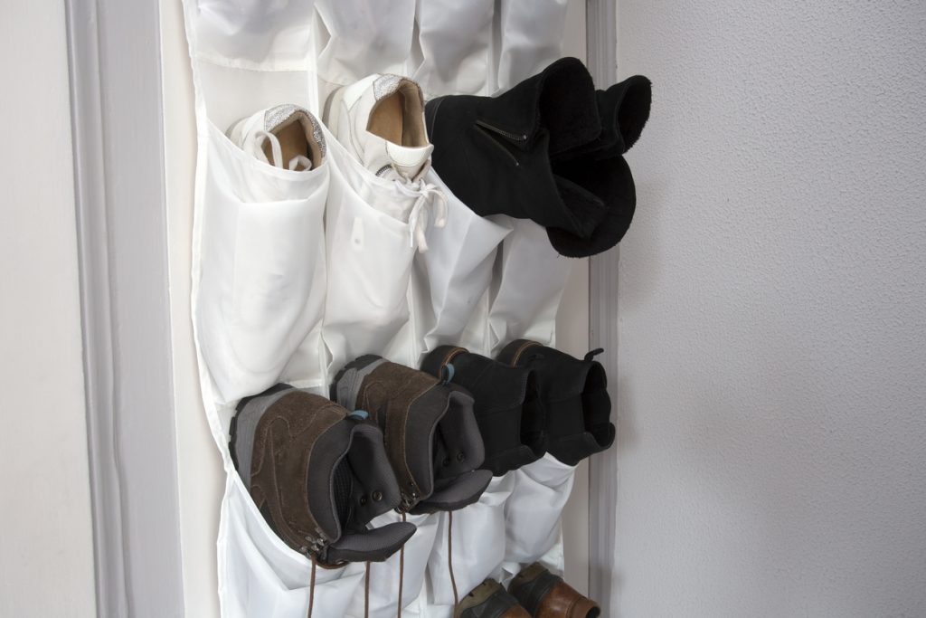 White cloth shoe rack hanging on a white wooden door
