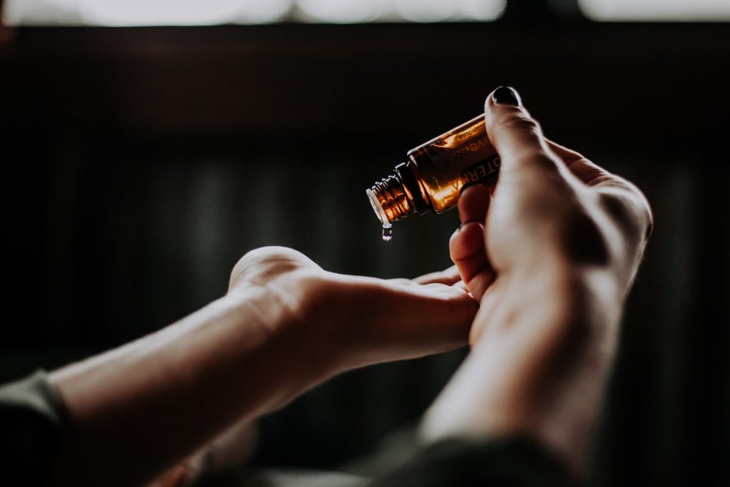 A woman pouring essential oils in her hands