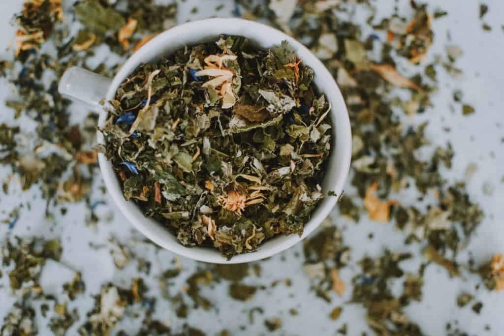 tea leaves in a cup and scattered around