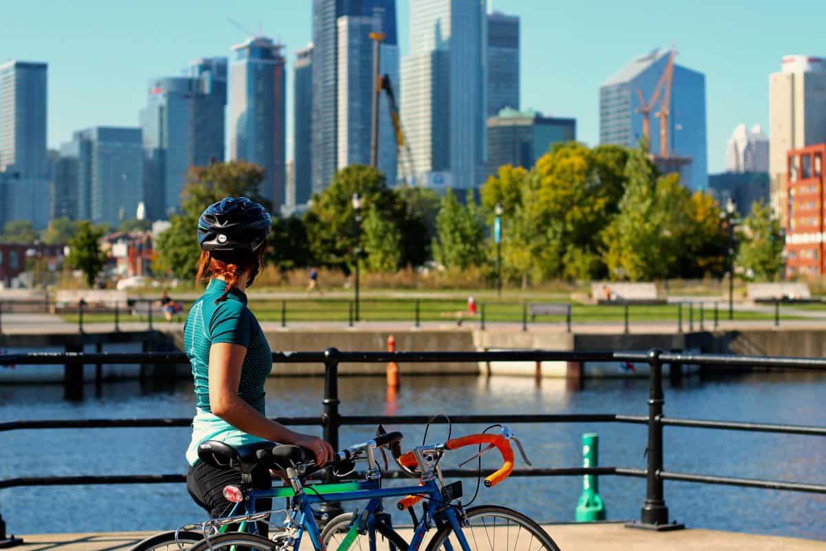a woman biking in montreal by a river