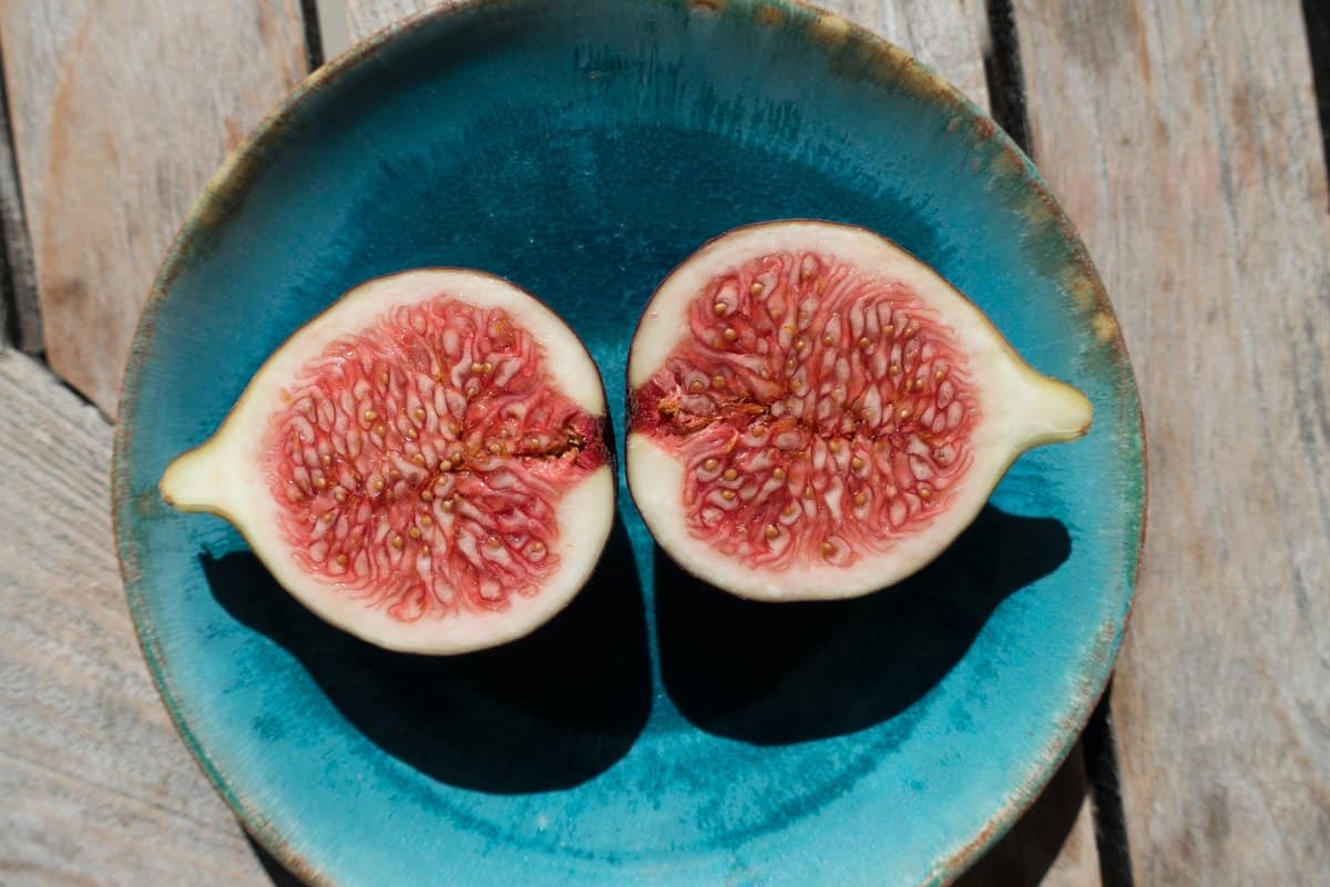 a sliced open fig on a blue plate