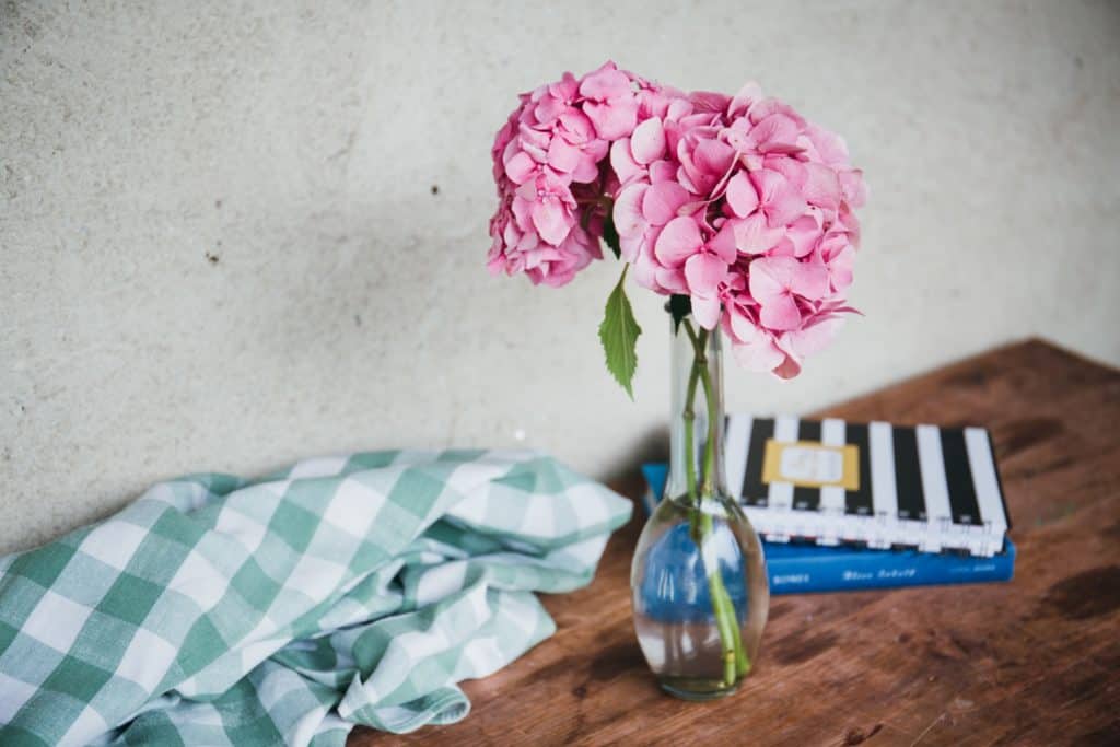 a shabby chic table setting with flowers and notebooks