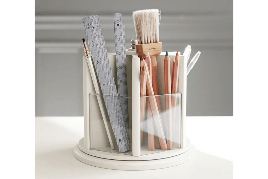 a clear and white lazy susan that holds office supplies