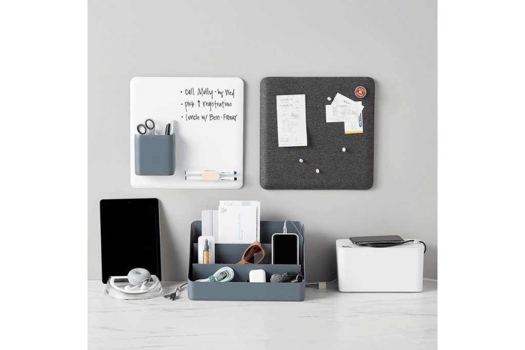 a grey home organizer that holds phones, cords, and notes