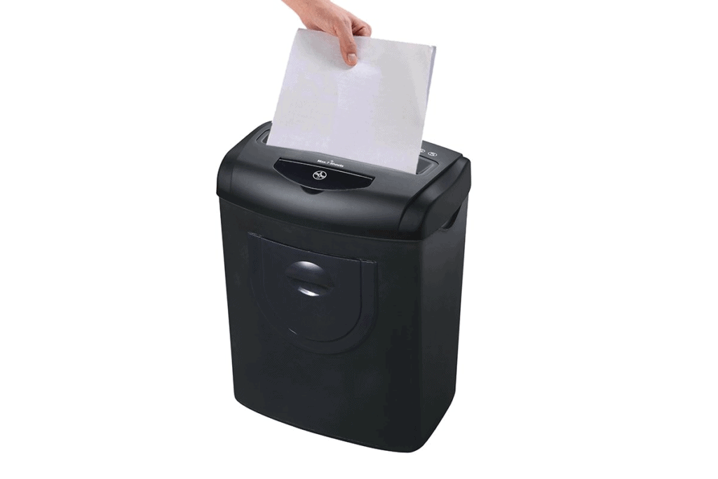 a person shredding a white piece of paper in a black paper shredder