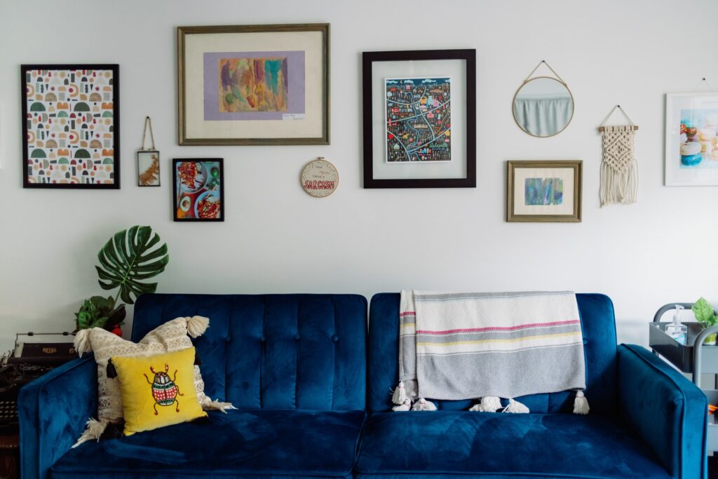 a variety of different hanging art pieces on a wall in a colorful living room