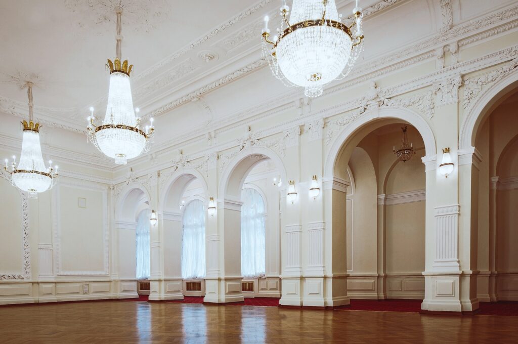 a large, ornate, well-lit ballroom with chandeliers