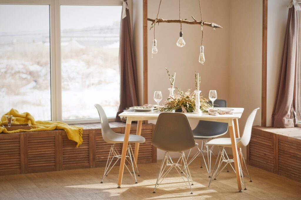 a neutral wooden decorated dining room with natural light flooding in from the window