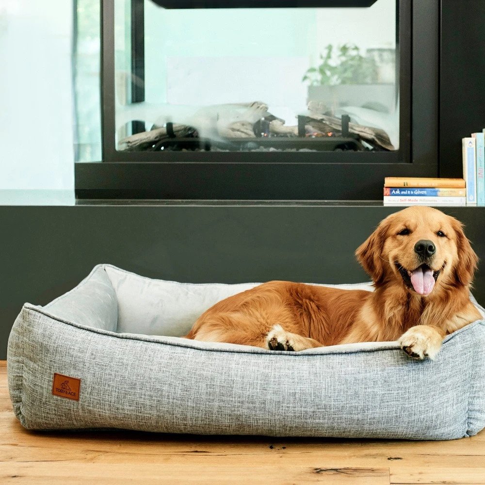 a grey dog bed with a golden retriever laying in it