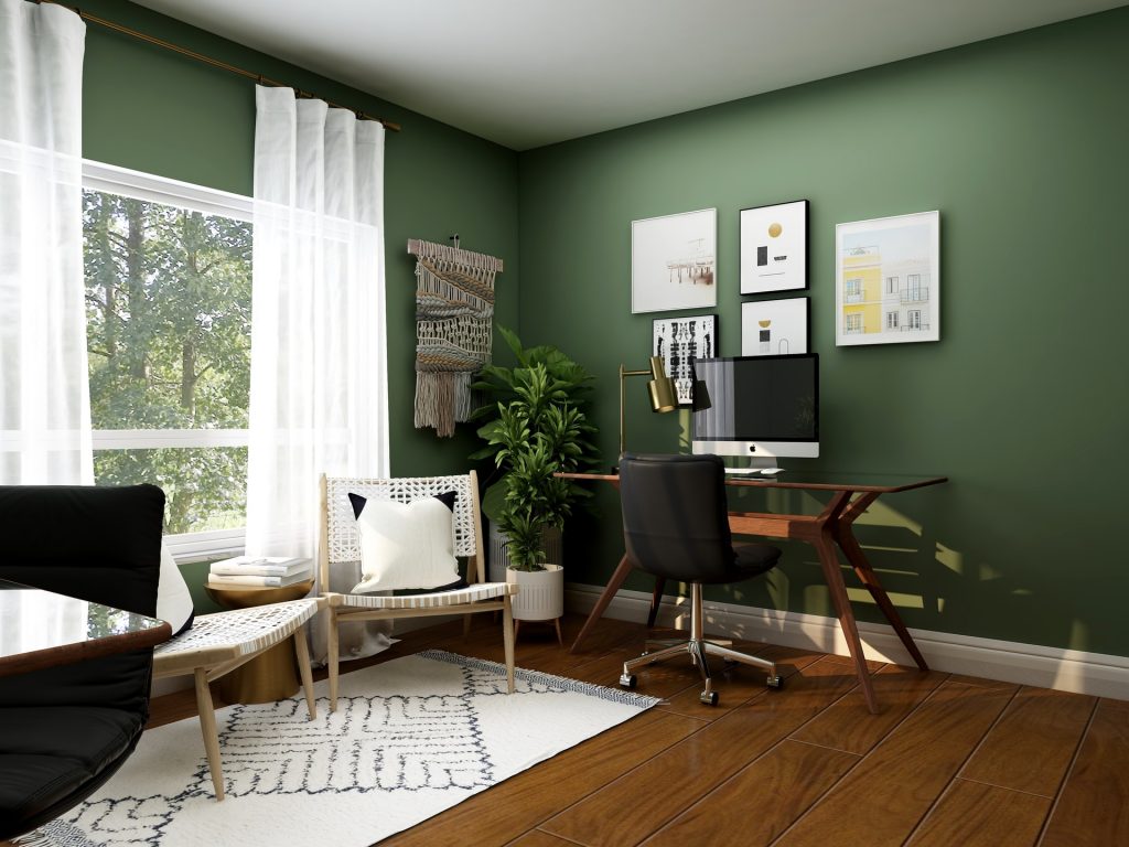 a mossy green room with a computer desk as a home office