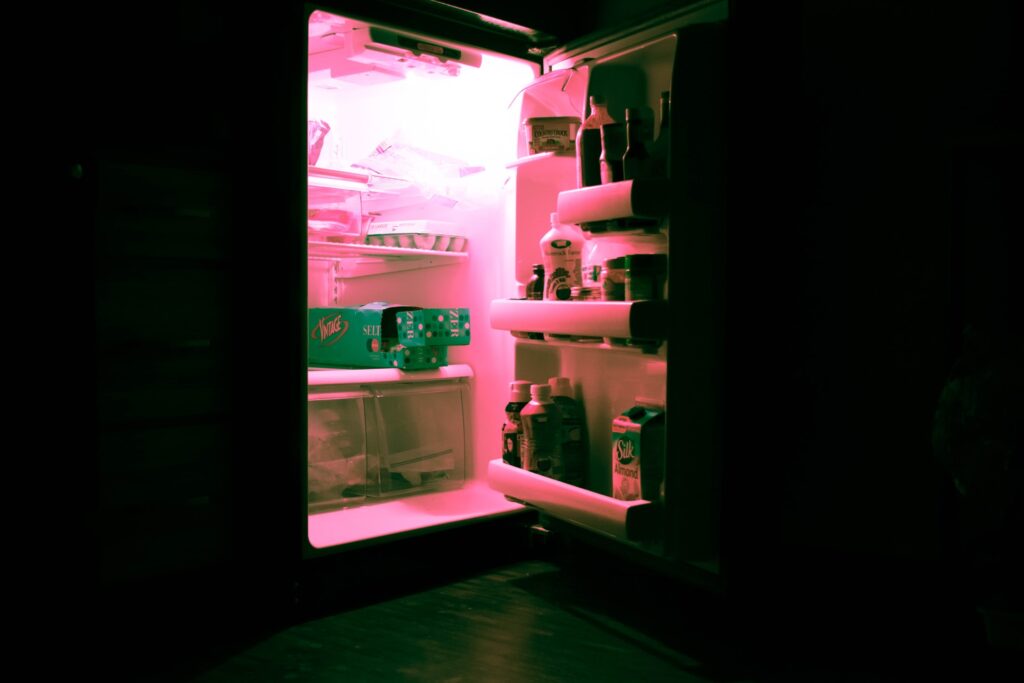A fridge open with a pink light