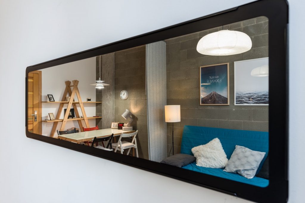 a long, full length mirror hanging on a wall
