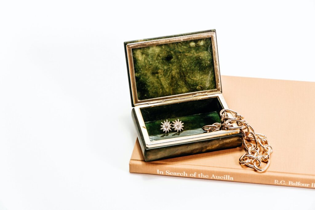 a green marble jewelry box with gold jewelry