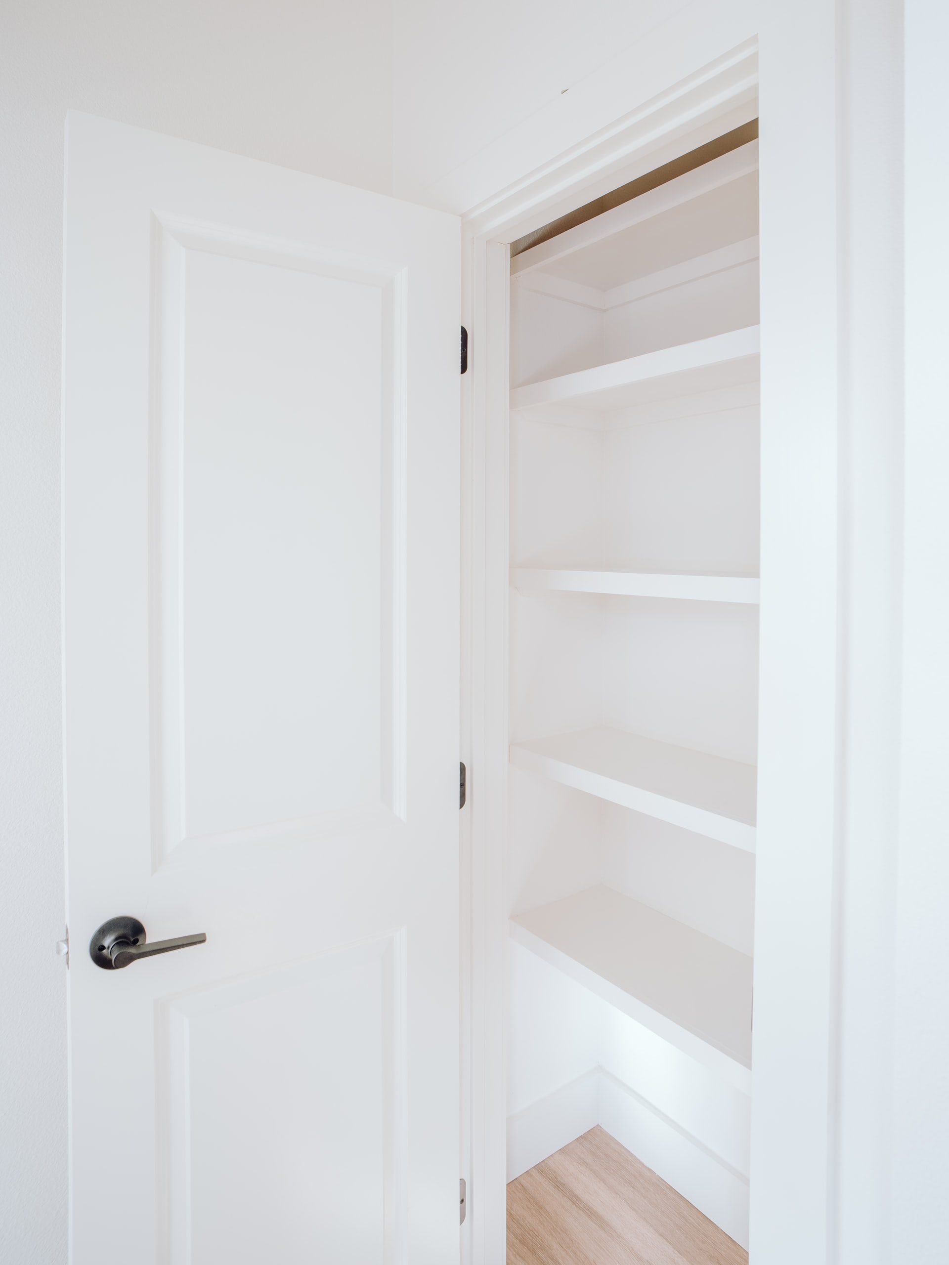 An opened, empty white closet to be turned into a mini bar design idea