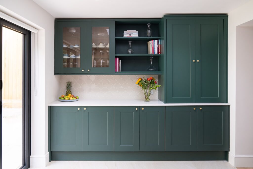 dark green kitchen cabinets with glassware