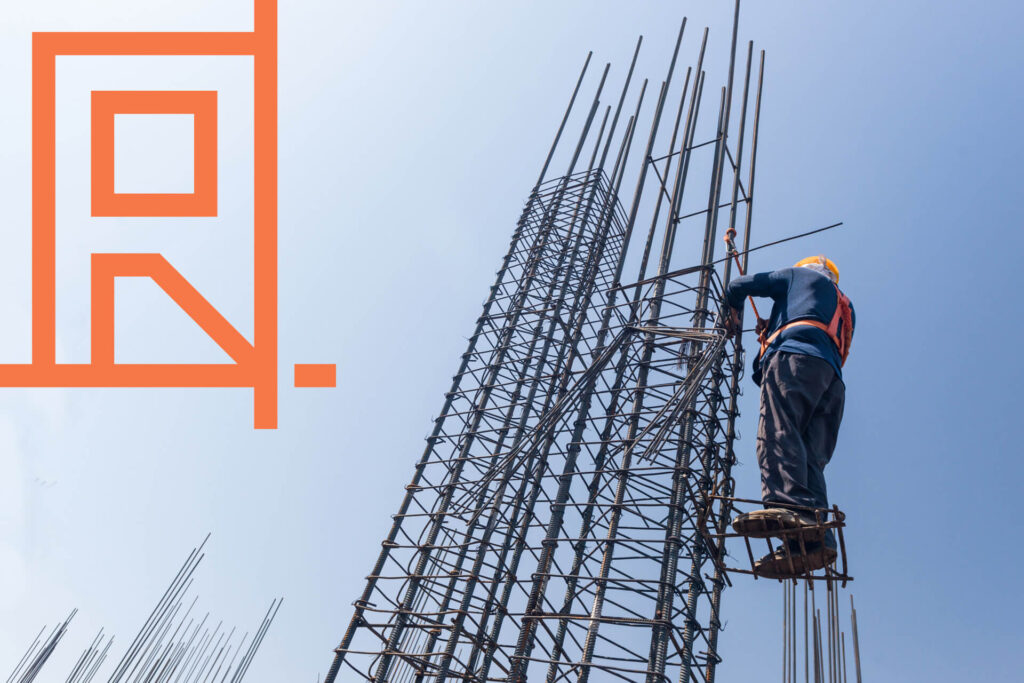 man in a hard hat climbing up a pole demonstrating uses of steel