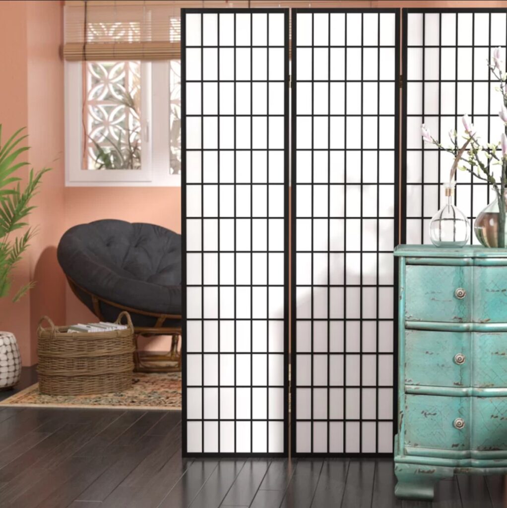 a white divider with black grid lines in a studio apartment
