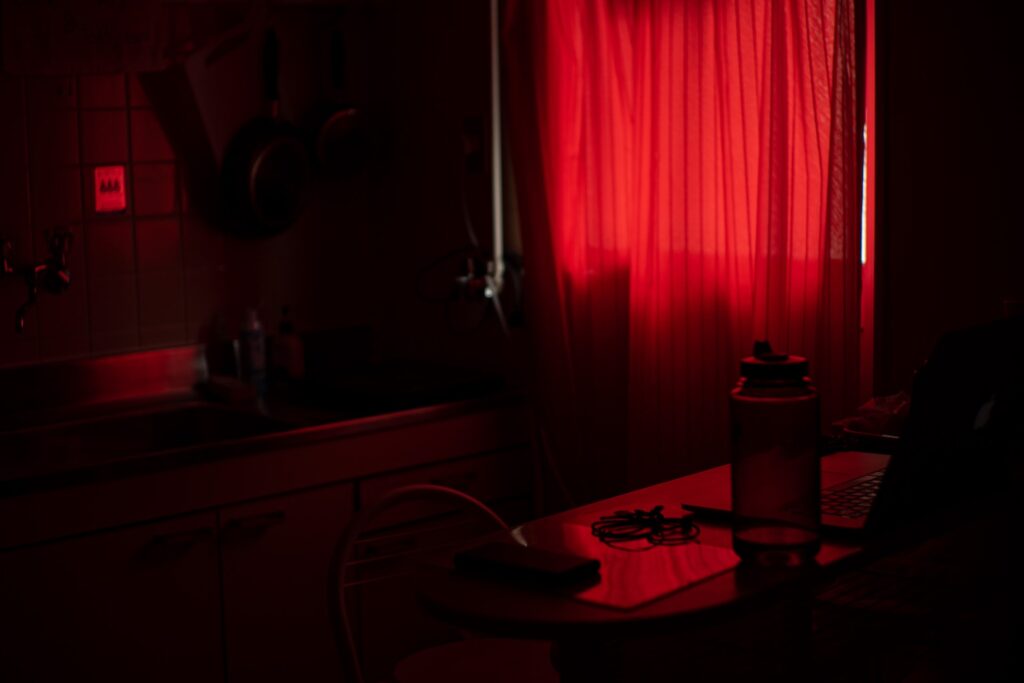 a kitchen with a red curtain that lights the room red