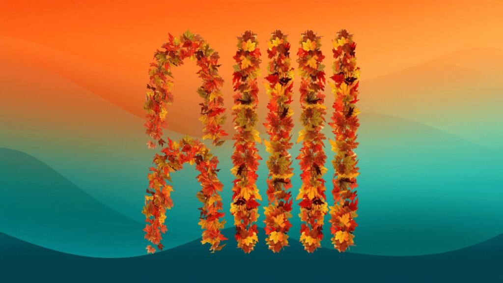 several strands of orange, yellow, and red fall garland in front of an orange and teal background