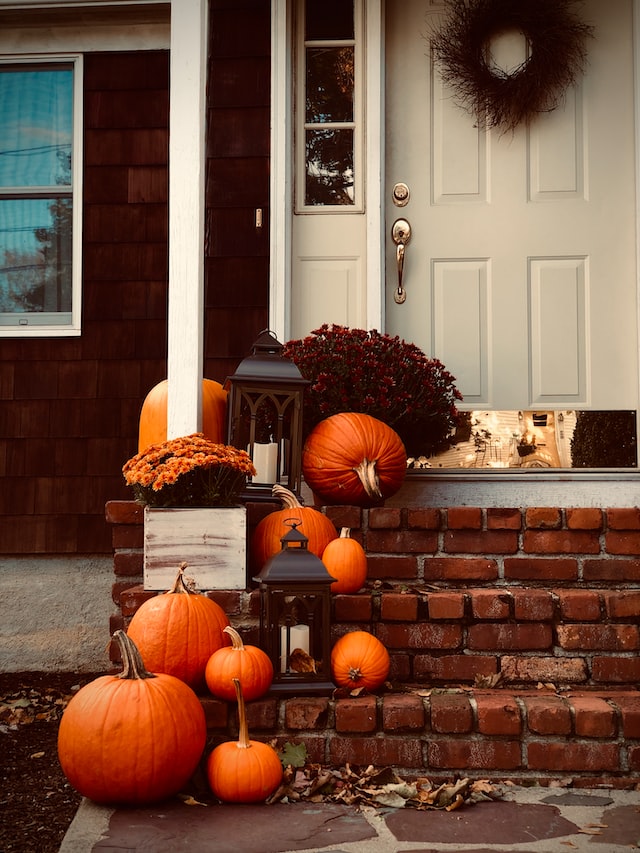 a variety of pumpkins and fall decor on a porch stoop