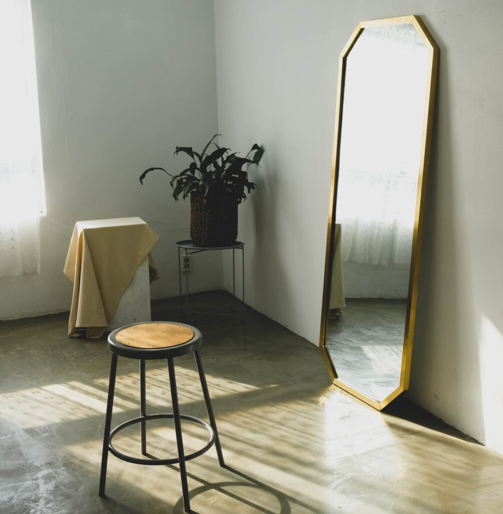 a gold mirror leaning against a wall in a room