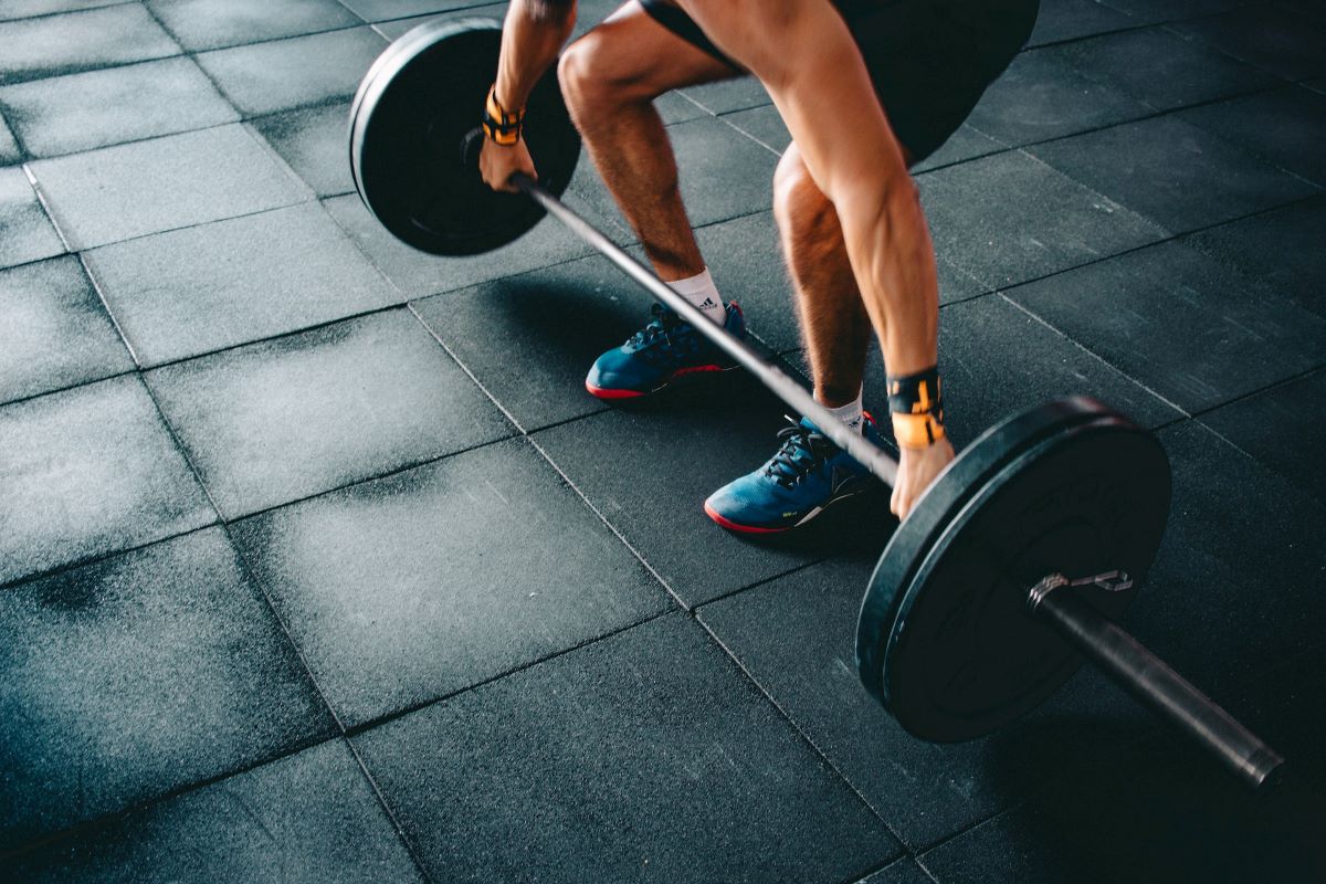 a man heavy lifting in his home gym with the perfect rubber flooring for basements