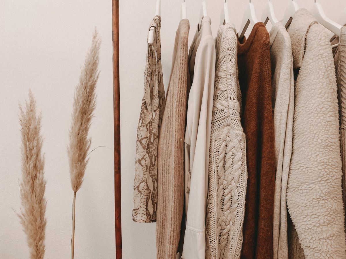 a rack with neutral sweaters ready for seasonal clothes storage