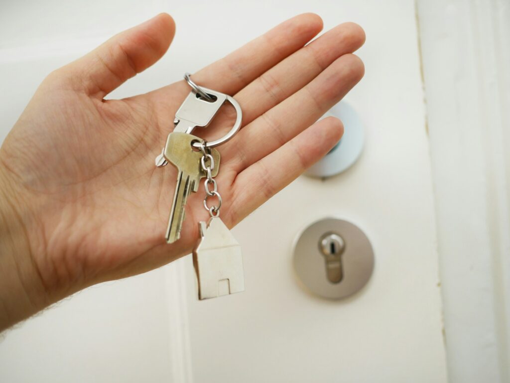 a hand holding keys to a house to symbolize an open house