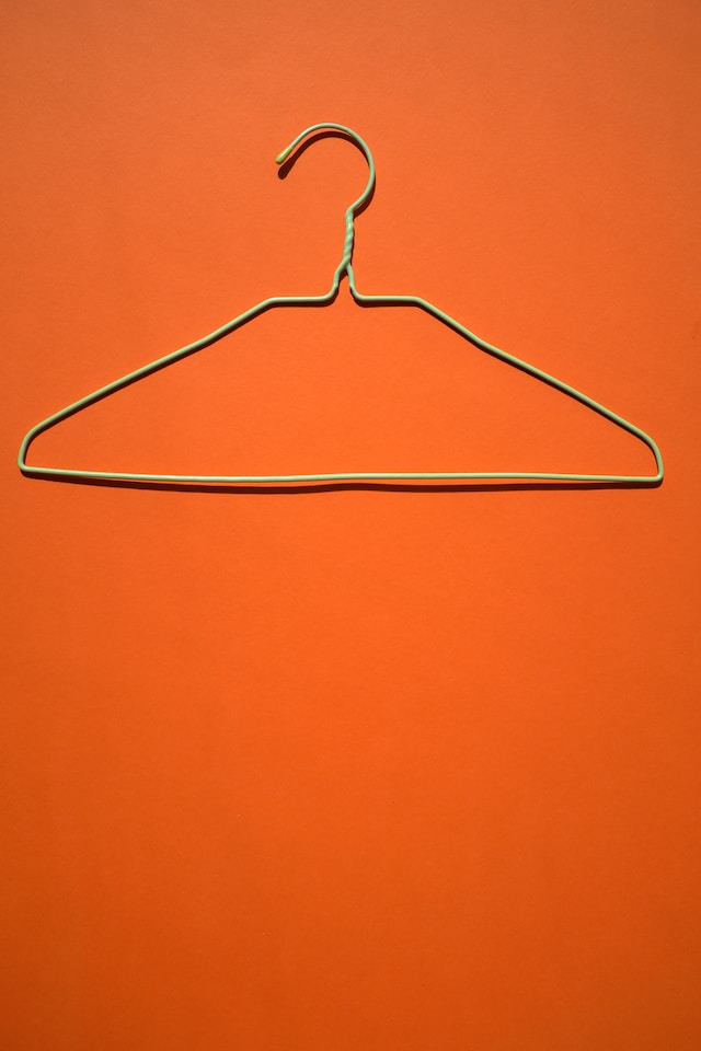 Metal hanger on orange background. 