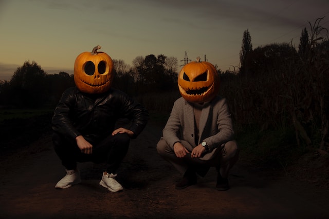 pumpkin carving ideas - two guys wearing carved pumpkin masks
