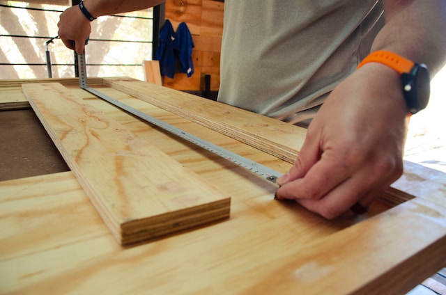 Entry construction jobs - a man measuring a piece of wood