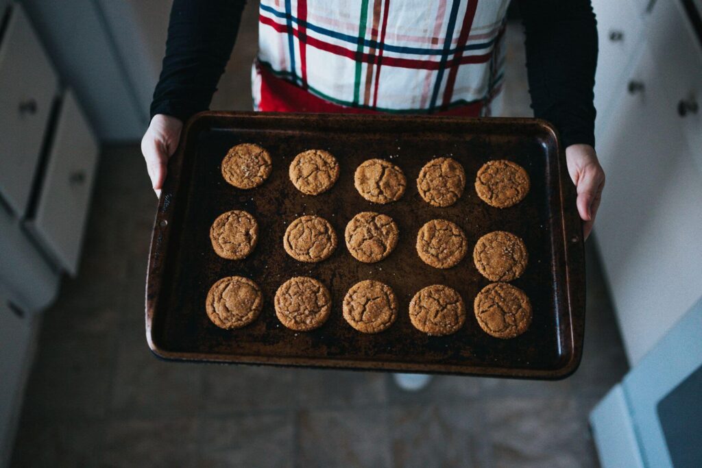 A person holding a tray of freshly baked cookies